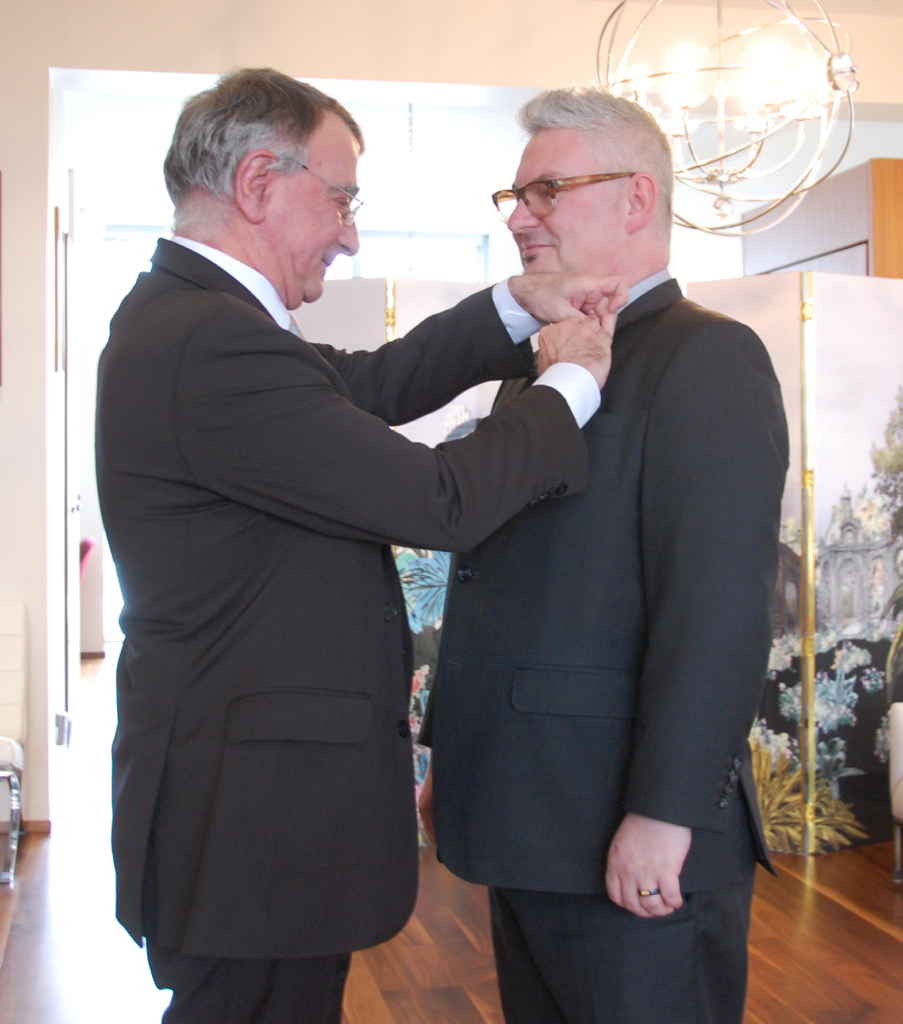 L'ambassadeur Nicolas Chapuis décore Marc Cormier de l'Ordre du Mérite.