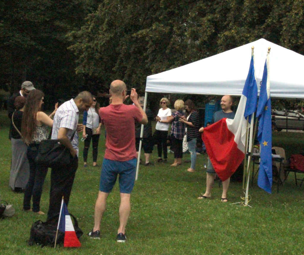 Plusieurs participants au pique-nique du «Bastille Day» se faisaient prendre en photo avec les drapeaux français et européen.