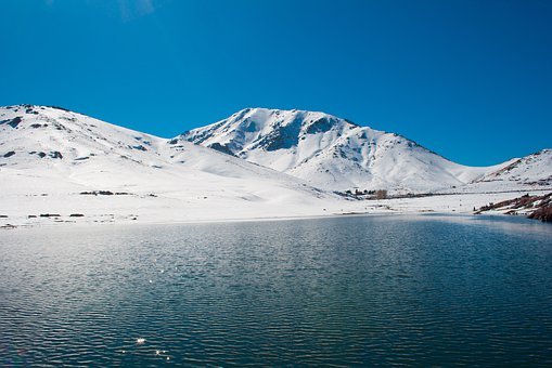 Lac devant une montagne enneigée de l'Atlas au Maroc