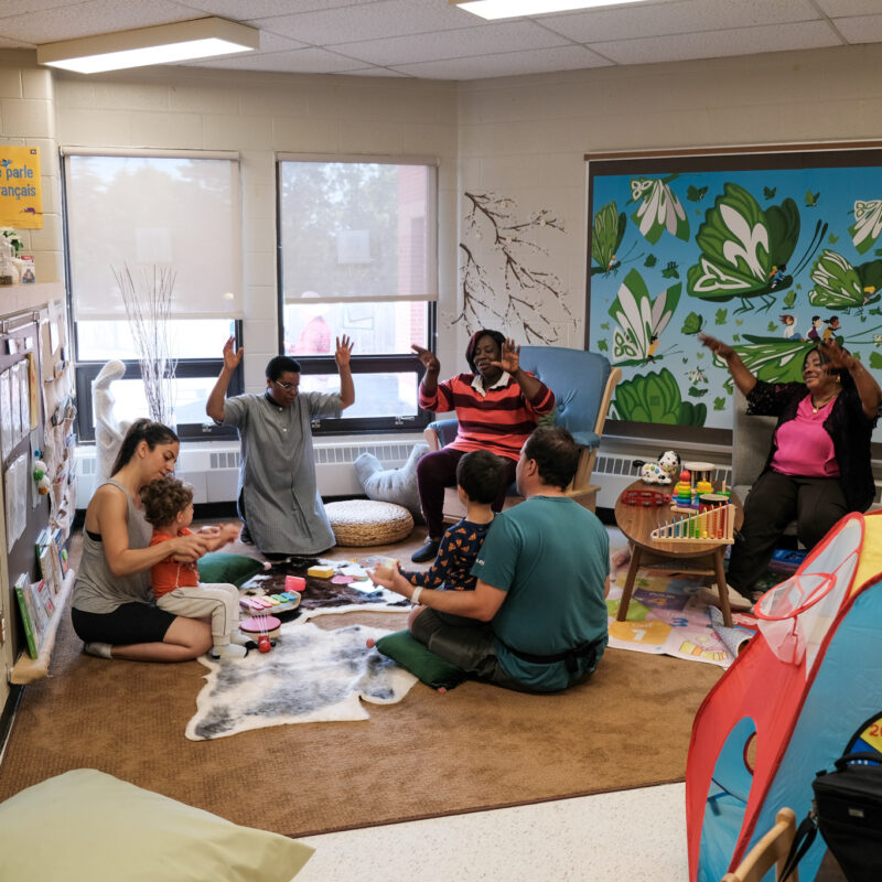 Maimouna Claloux, assistante de programme, Adolphine Kambayire, Intervenante à la petite enfance et Marie Nyamabu, Gestionnaire des services de l'enfance et famille, jouant avec des enfants au centre ON y va de Markham.